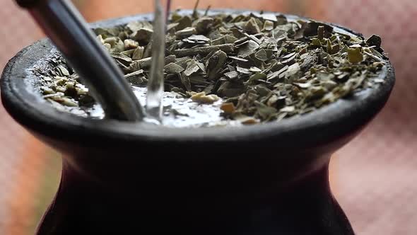 Pouring water into a "mate" gourd. Traditional Argentinian infusion. Medium closeup.