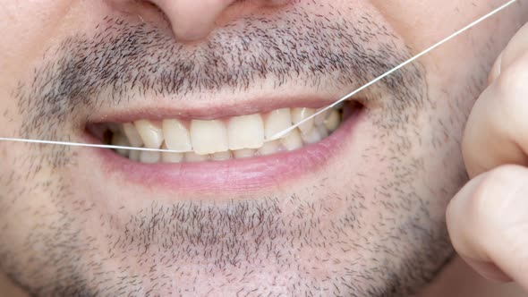 close up 4k video young man mouth,smiling and flossing teeth.beautiful smile, bearded male.natural