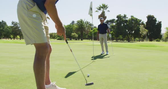 Two caucasian senior man practicing golf at golf course on a bright sunny day