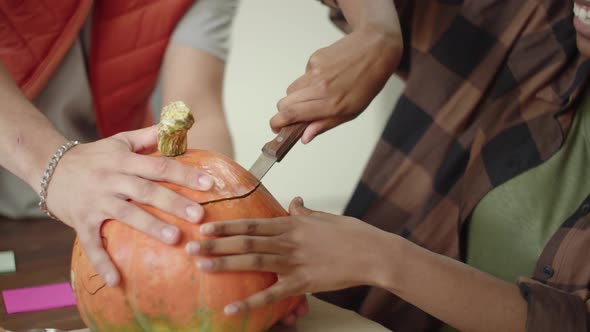 A Handsome Young Lady is Carving the Pumpkin