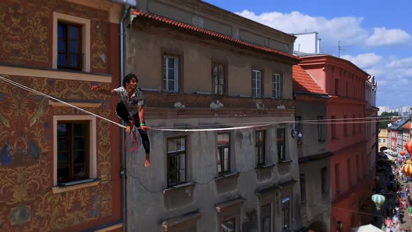 Man Balances on Tight Rope a View of the City From Height