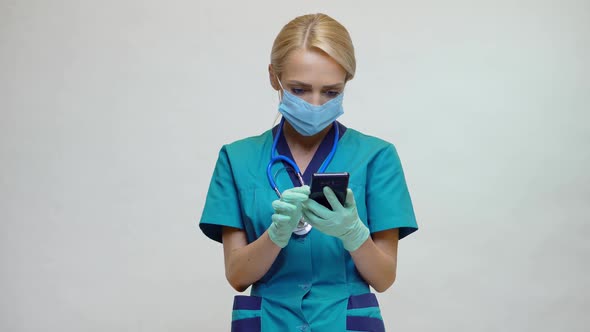 Medical Doctor Nurse Woman Wearing Protective Mask and Latex Gloves - Talking on the Phone