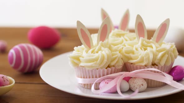 Cupcakes with Easter Eggs and Candies on Table