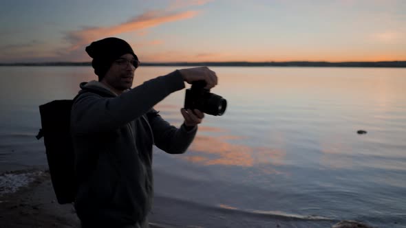 Young Man Photographer Taking Pictures with a Professional Camera By the Torrevieja Pink Lake at