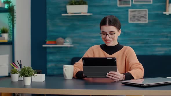 Young Adult Wokring on Digital Tablet with Stylus to Write Report alt