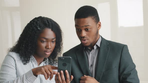 Surprised Excited Black Man and Woman Looking at Cell Phone Screen Overjoyed Read Good Internet News
