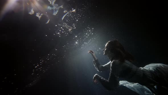 Beautiful Young Woman is Floating Under Water Surface Magic Subaquatic Slow Motion Shot