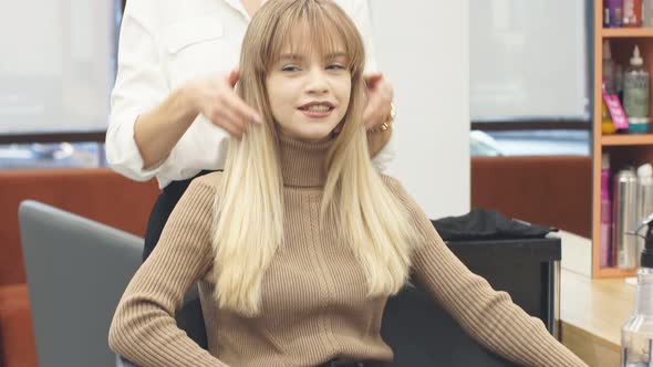 Careful Hairdresser Holding Client's Hair in Hands