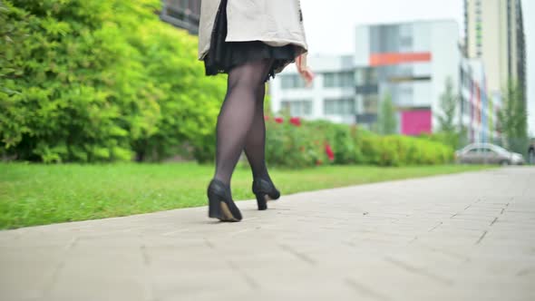 Legs of woman walking fast on the sidewalk in the street, bottom close-up