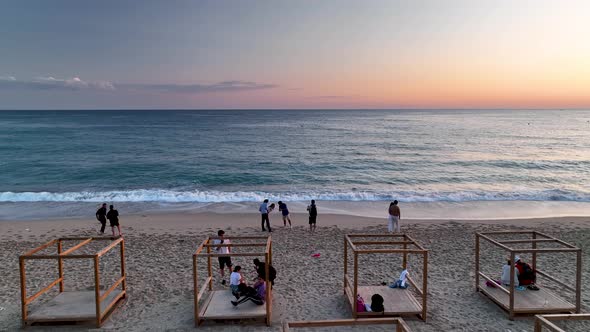 People sit on the beach and watch the sunset