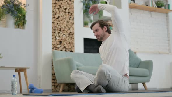 Young Man Doing Yoga on Yoga Mat at Home