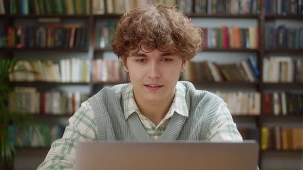 Handsome Curly Student Man Using Laptop Search Information Internet Course Study Online e Learning alt