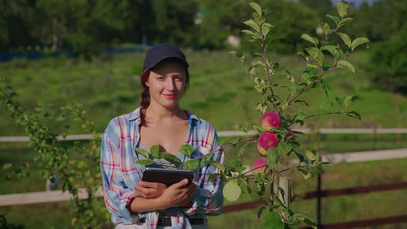 Young Female Farmer in Fruit Orchard