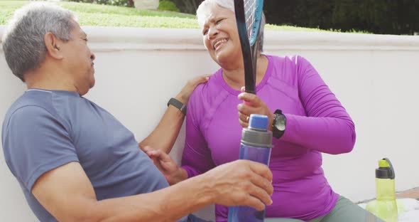 Video of biracial senior couple laughing and embracing after match on stands