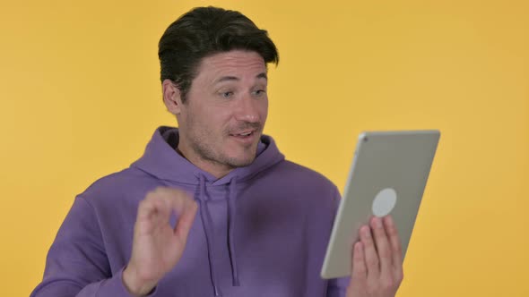 Video Chat on Tablet By Man, Yellow Background 