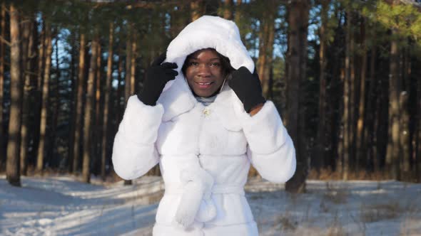 AfricanAmerican Girl Poses Against Trees in Winter Park