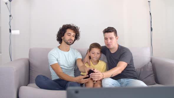 Two Focused Fathers and Son Setting Parameters on New TV