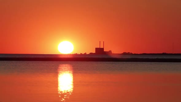 Sun just at horizon, beautiful sunset, view of power plant