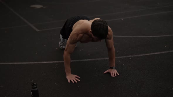 A muscular guy is pushing up while training