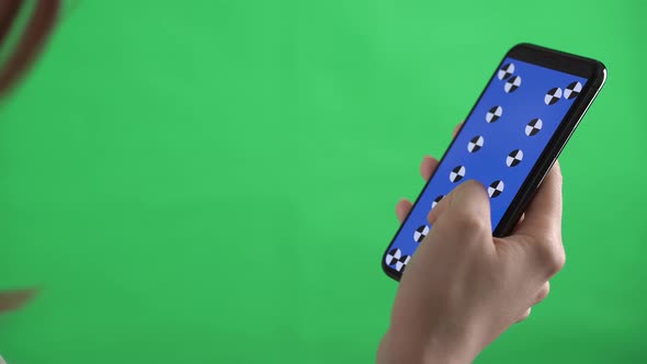 Hands of a Caucasian Woman Holding the Phone with Tracking Points on It and Swiping on Green Screen