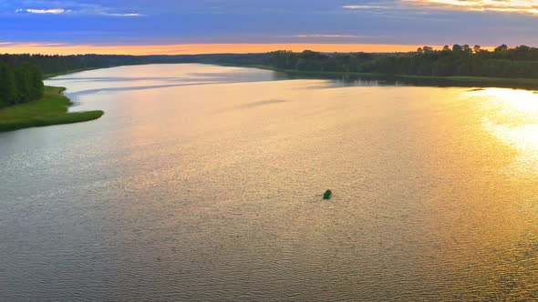 Lonely boat on lake in summer at sunset, aerial view