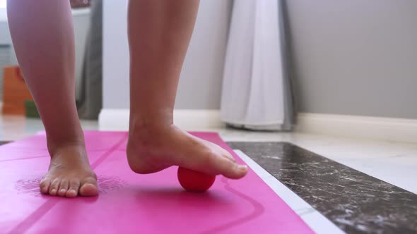 Woman Massages the Foot with a Ball