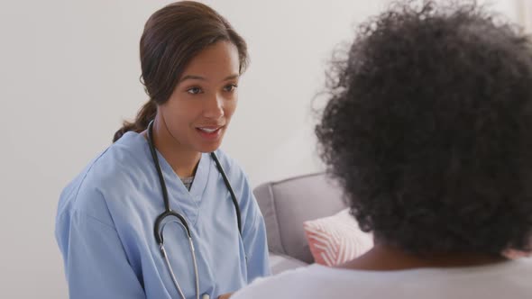 Mixed race woman being visited at home by a nurse. Social distancing and self isolation in quarantin