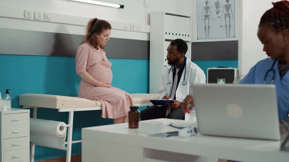 African American Medic Taking Notes at Examination with Future Mother