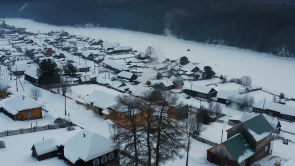 Aerial View of Smoke Coming From Stoves in Wooden Houses in the Village in Winter
