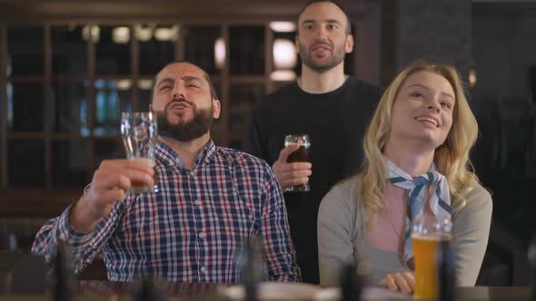 Confident Positive Caucasian Men and Woman Singing National Anthem Watching Match in Pub Indoors