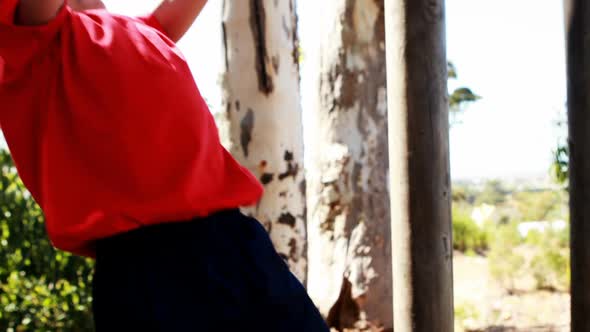 Boy performing pull-ups on bar during obstacle course