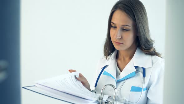 Female Doctor Taking a Folder in Medical Clinic