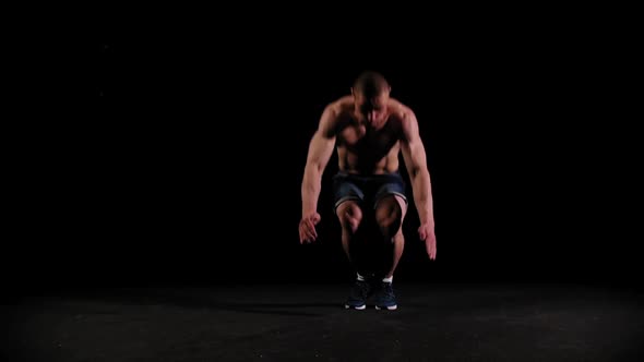 Young Pumped Man Doing Back Flips in the Dark Arena