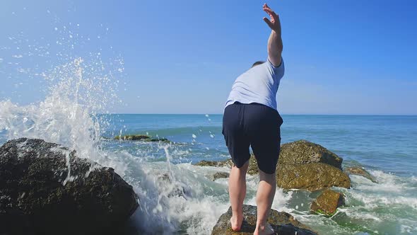 Guy Climbs Up on Wet Rock