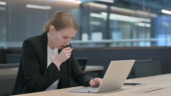 Businesswoman Coughing While Using Laptop at Work