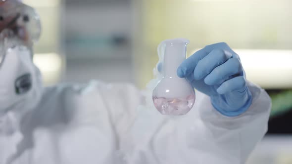 Chemist in Protective Gear Observing Chemical Reaction alt