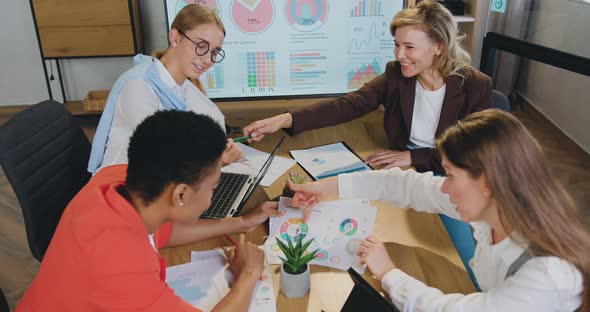 Business Women Brainstorm on Paperwork Talk Engaged in Teamwork at Corporate Briefing