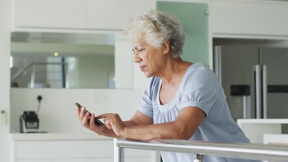 African american senior woman using smartphone at home