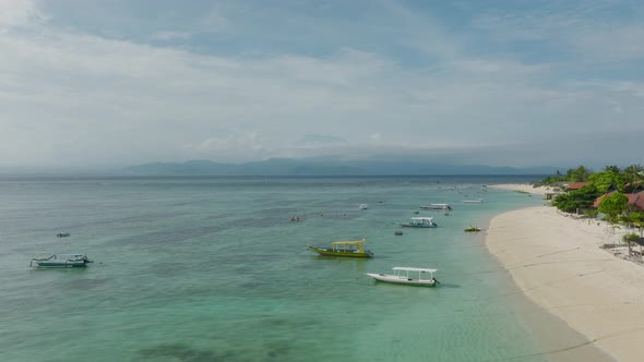 Pantai Pasir Putih beach on Nusa Lembongan with local boats, sunny day, seaweed farm