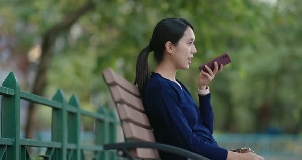 Young Woman work on mobile phone and sit on the bench