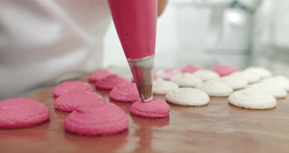 Piping Out Pink Macaron Mixture On A Slip Mat On Backing Tray Chef Making