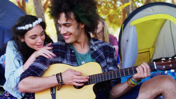 Man playing guitar for his woman in park 4k