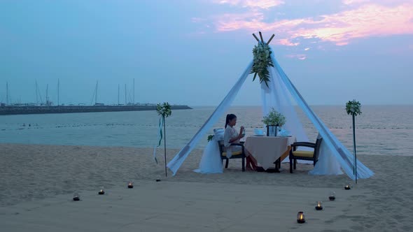 Woman Having Romantic Dinner with Candle Lights on the Beach in Thailand Asian Woman Dinner on the