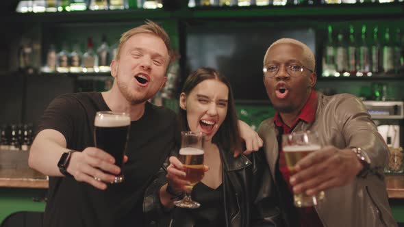 Cheerful Friends With Beer Glasses At Bar