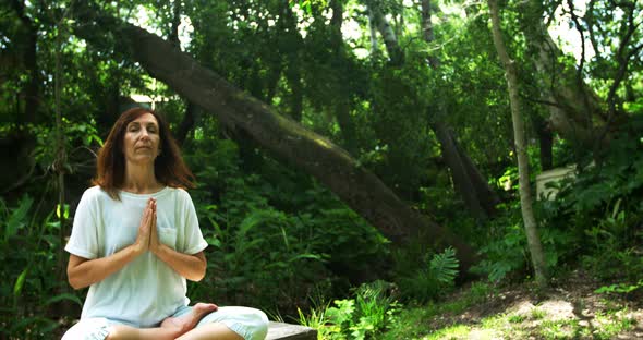 Mature woman performing yoga in the park 4k