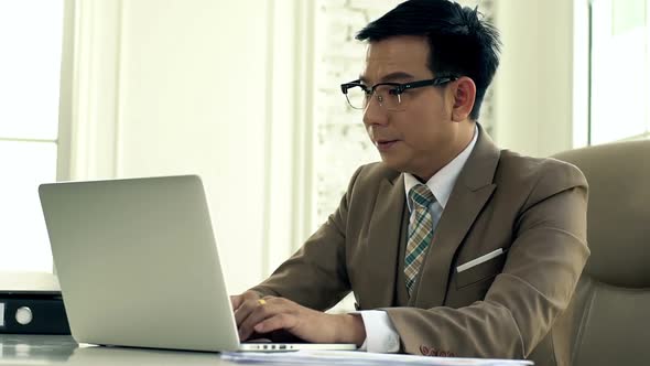 Asian Business man Working on a Laptop Intense 05