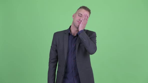 Stressed Businessman in Suit with Face Palm