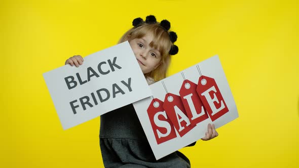 Cheerful Blonde Child Girl Showing Black Friday and Sale Word Advertisement Inscriptions Banners