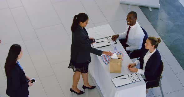 Businesswoman checking in at conference registration table 4k