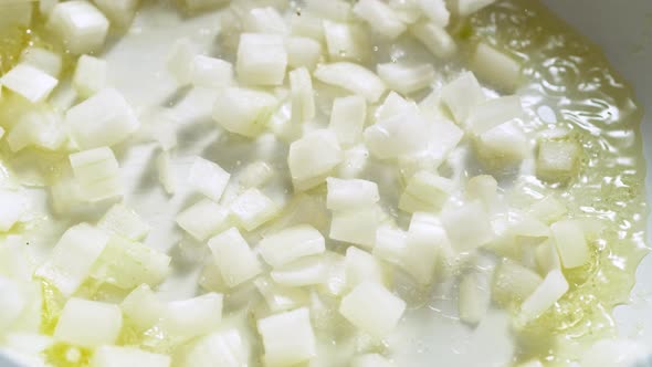 Cooking chopped onion in heated olive oil. Slow Motion. alt